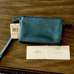 Brand new Coach metallic blue wristlet. 2 zipper pockets with ID & card holder.